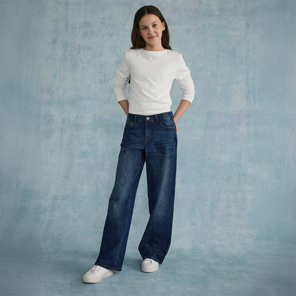 Haut blanc texturé associé à un jean ample et des baskets blanches.