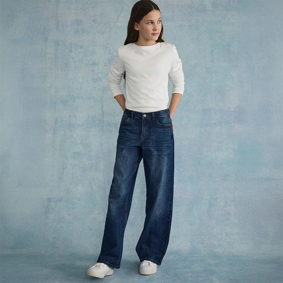 Haut blanc texturé associé à un jean ample et des baskets blanches.