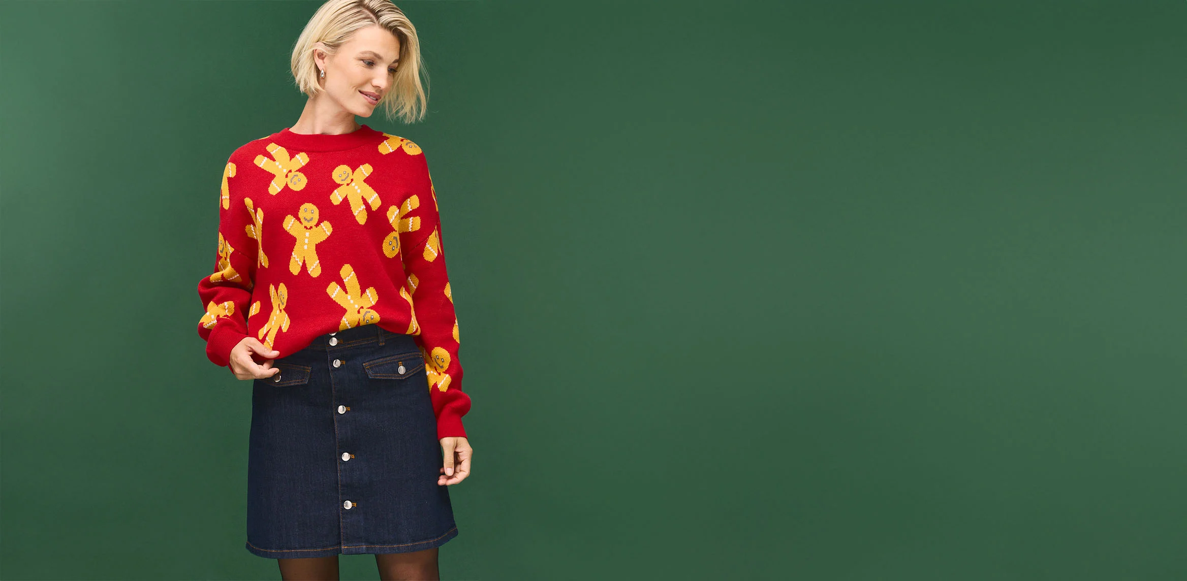 Pull rouge à motifs bonshommes en pain d'épices et jupe en jean foncé à boutons mode.